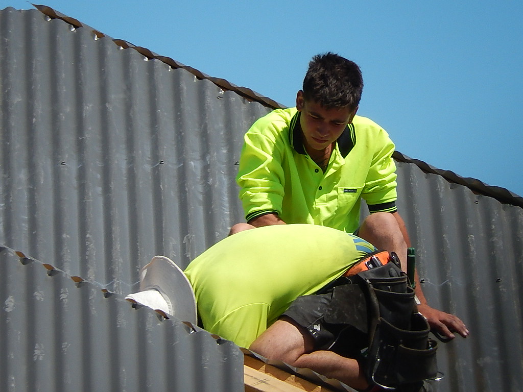Worker in hi-vis on a corrugated metal roof